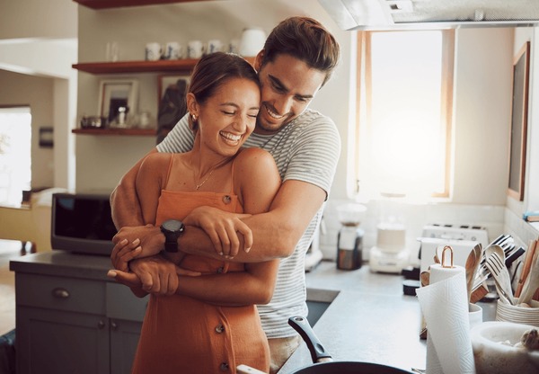 Young Couple With Dog Dancing in the Kitchen Stock Photo